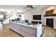 Open living room with a cozy gray sofa, fireplace, and a view of the dining area at 108 Fieldbrook Xing, Holly Springs, GA 30115