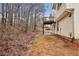 Backyard with wooden deck featuring natural views of trees and a home exterior at 1559 Hillary Cove Ct, Lawrenceville, GA 30043