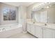 Bathroom with a double sink vanity, soaking tub, and large window at 1559 Hillary Cove Ct, Lawrenceville, GA 30043