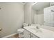 Clean bathroom with a single sink vanity, toilet, and shower with white tiling at 1559 Hillary Cove Ct, Lawrenceville, GA 30043