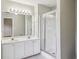 Bathroom with double sink vanity, large mirror, and glass-enclosed shower at 1559 Hillary Cove Ct, Lawrenceville, GA 30043