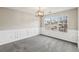 Bright dining room has wainscoting, plush carpet, neutral paint, and a big window overlooking the front yard at 1559 Hillary Cove Ct, Lawrenceville, GA 30043