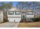 Charming two-story home boasts a two-car garage, stone accents, green shutters, and a neatly landscaped front yard at 1559 Hillary Cove Ct, Lawrenceville, GA 30043