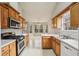 Cozy eat-in kitchen with wood cabinets, white countertops, modern appliances, and an adjacent breakfast area at 1559 Hillary Cove Ct, Lawrenceville, GA 30043