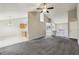 Spacious open-plan living room with gray carpet and neutral walls adjacent to the staircase and kitchen areas at 1559 Hillary Cove Ct, Lawrenceville, GA 30043