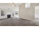 Bright living room features a fireplace, neutral walls, plush carpet, and large windows that overlook the backyard at 1559 Hillary Cove Ct, Lawrenceville, GA 30043