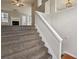 View of a carpeted staircase leading to a living room with a fireplace and ample natural light at 1559 Hillary Cove Ct, Lawrenceville, GA 30043