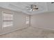 This main bedroom features neutral walls, carpeting, trey ceiling, and a ceiling fan at 305 Long Creek Dr, Covington, GA 30016