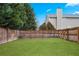 Large, fenced backyard with lawn and mature trees, creating a private oasis at 5998 Graywood Se Cir, Mableton, GA 30126