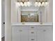 Bathroom showcasing double vanity sinks and expansive mirror with decorative lighting at 145 Meadow Branch Ln, Dallas, GA 30157