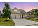 Charming exterior view of home featuring a stone and siding facade and a two-car garage at sunset at 145 Meadow Branch Ln, Dallas, GA 30157