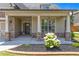 Close-up view of a home's inviting front porch featuring stone pillars and a landscaped flower bed at 145 Meadow Branch Ln, Dallas, GA 30157
