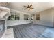 Enclosed patio with a stone fireplace, ceiling fan, and wood-look floors for comfort and style at 145 Meadow Branch Ln, Dallas, GA 30157