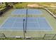 Aerial view of two well-maintained tennis courts surrounded by fencing and greenery at 145 Meadow Branch Ln, Dallas, GA 30157