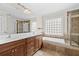 Primary bathroom featuring double sink vanity, soaking tub, glass block window, and walk-in shower at 1880 Eastfield St, Decatur, GA 30032