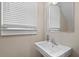 Cozy bathroom featuring a pedestal sink, window with blinds, and neutral color palette at 1880 Eastfield St, Decatur, GA 30032