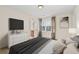 Cozy bedroom with a large bed, dresser with TV, and window with curtains at 1880 Eastfield St, Decatur, GA 30032