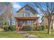 Charming two-story home features a covered front porch and is surrounded by mature landscaping at 1880 Eastfield St, Decatur, GA 30032