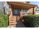 Welcoming front porch with swing is framed by brick columns and lush landscaping, offering a cozy outdoor space at 1880 Eastfield St, Decatur, GA 30032