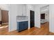 Hallway with blue cabinets, hardwood floors, and black door at 1880 Eastfield St, Decatur, GA 30032