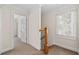Upstairs hallway with railing, window, and doorways to other rooms at 1880 Eastfield St, Decatur, GA 30032