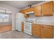 Well-lit kitchen with wood cabinetry, white appliances, and views into the dining and living areas at 521 Carlsbad Cv, Stockbridge, GA 30281