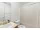 Neutral bathroom featuring a white shower curtain, sink, and toilet at 7235 Magnolia Ln, Fairburn, GA 30213