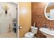 Powder room featuring tan walls, an oval mirror, commode, and an adjacent storage room at 7235 Magnolia Ln, Fairburn, GA 30213