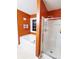 Bright bathroom with shower, soaking tub, and unique orange walls at 7235 Magnolia Ln, Fairburn, GA 30213