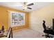 Bedroom with tan walls, ceiling fan and large window with a street view at 7235 Magnolia Ln, Fairburn, GA 30213