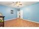 Spacious blue bedroom with wood floor and open door at 7235 Magnolia Ln, Fairburn, GA 30213