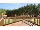 This is a backyard deck featuring stained wood railings and planks, with trees lining the back of the yard at 7235 Magnolia Ln, Fairburn, GA 30213