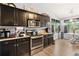 Kitchen with stainless steel appliances, dark cabinets, granite countertops, and a breakfast nook at 7235 Magnolia Ln, Fairburn, GA 30213