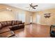 Open-concept living room with laminate flooring and a brown leather couch at 7235 Magnolia Ln, Fairburn, GA 30213