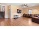 Large living room with laminate flooring, brown leather couch, and stairway at 7235 Magnolia Ln, Fairburn, GA 30213