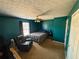 Bedroom features a queen-size bed, teal walls, ceiling fan, and natural light from the windows at 226 Saul Dr, Ellenwood, GA 30294