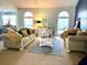 Cozy living room with neutral furniture, decorative rug, and lots of natural light from large arched windows at 226 Saul Dr, Ellenwood, GA 30294