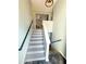 View of a carpeted staircase with modern gray paint and black handrails, leading to the upper level of the home at 226 Saul Dr, Ellenwood, GA 30294