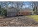 Back of the house featuring a spacious deck and a screen porch addition, nestled among the trees and leaves at 4391 Shiloh Hills Dr, Snellville, GA 30039