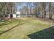 Expansive backyard with a shed, offering plenty of space for outdoor activities surrounded by mature trees at 4391 Shiloh Hills Dr, Snellville, GA 30039