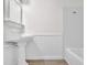 Bathroom featuring a pedestal sink, beadboard paneling, and a shower-tub combo at 4391 Shiloh Hills Dr, Snellville, GA 30039