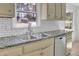 Kitchen featuring a stainless steel sink, a dishwasher, and a white subway tile backsplash at 4391 Shiloh Hills Dr, Snellville, GA 30039