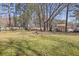 View of the wide open yard, surrounded by mature trees that offer natural privacy from neighbors at 4391 Shiloh Hills Dr, Snellville, GA 30039