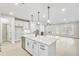 Open kitchen with center island, pendant lighting, and stainless steel appliances at 5769 Tillman Way, Powder Springs, GA 30127