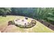 Backyard featuring a fire pit and stone surround, grill, and black fence at 132 Hammond Dr, Canton, GA 30114