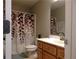 Well-lit bathroom featuring a vanity with drawers and a shower with a decorative leaf patterned curtain at 132 Hammond Dr, Canton, GA 30114