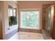 A soaking tub sits under a window in this bright main bathroom with glass enclosed shower at 132 Hammond Dr, Canton, GA 30114