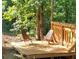 Outdoor patio featuring two wooden chairs surrounded by lush trees and greenery at 132 Hammond Dr, Canton, GA 30114