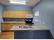 Charming kitchen with blue walls, wooden cabinetry, stainless steel microwave, oven, and granite countertops at 1470 Andrews Nw St, Atlanta, GA 30314