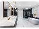 Luxury bathroom with a freestanding tub, glass shower, double vanity with gold accents, and marble floors at 1798 Braselton Hwy, Lawrenceville, GA 30043